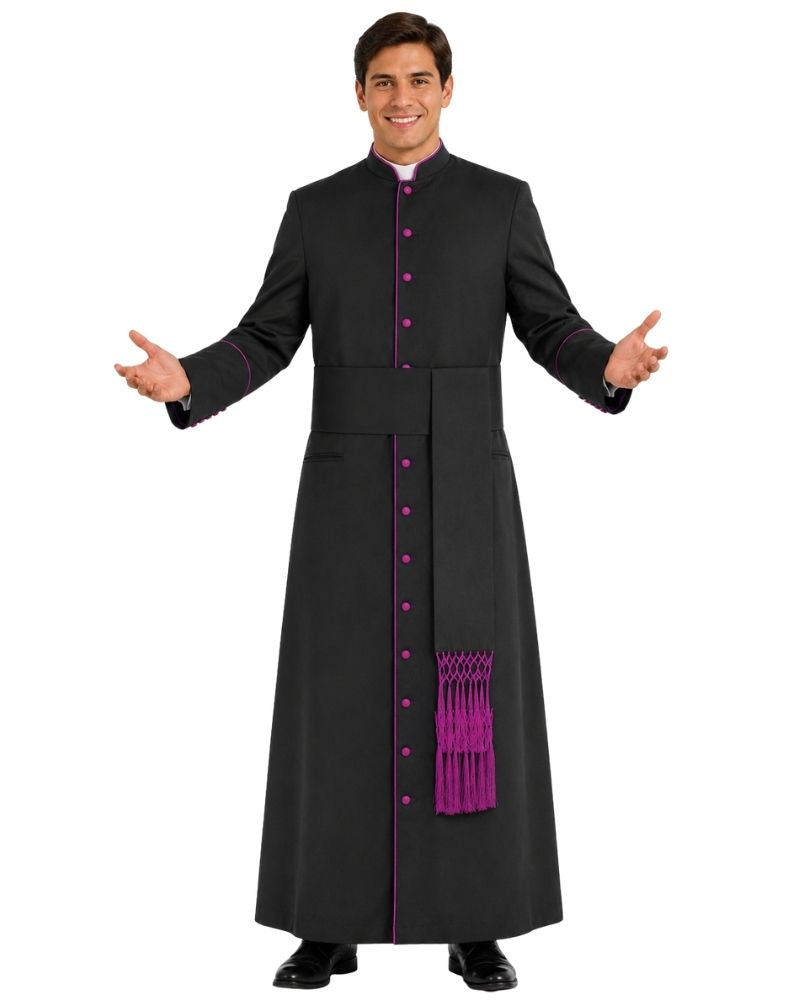 A man modeling a long black clerical cassock with bright purple trim, buttons, and decorative fringe, posed against a plain white background.