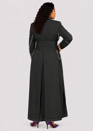 Woman wearing a long black robe with white piping on a light gray background