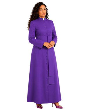 A woman modeling a long-sleeved purple clerical cassock with a high collar, front button closure, and a matching belt, shown against a plain white background.