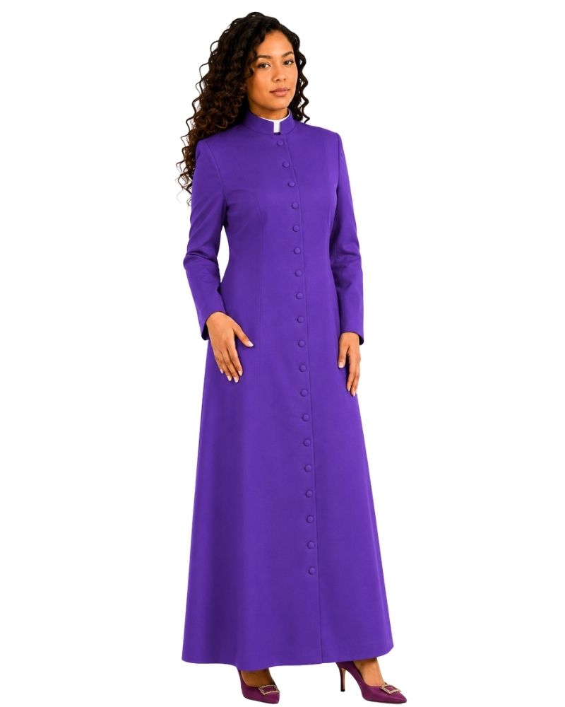 A woman modeling a long-sleeved purple clerical cassock with a high collar, front button closure, and a small white collar tab, set against a plain white background.