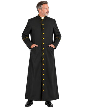 A man wearing a Black Roman Cassock With Yellow Trim, standing against a plain white background.