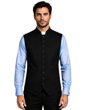 A man wearing a black button-front waistcoat vest over a light blue dress shirt and black trousers, shown against a white background.