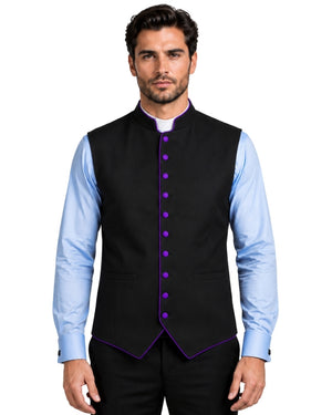 A man wearing a black waistcoat with purple trim and purple buttons, layered over a light blue dress shirt and black trousers, against a white background.