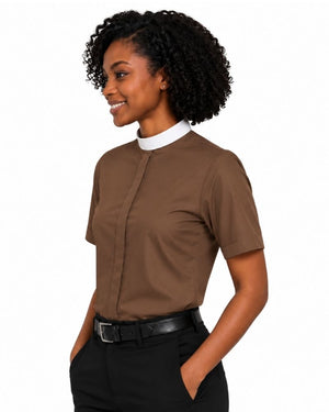 A woman with curly black hair is shown in profile wearing a brown short-sleeve clerical shirt with a white inner collar, paired with black pants and a black belt, against a plain white background.