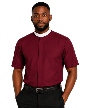 A man wearing a burgundy short-sleeve clerical shirt with a white collar, paired with black trousers and a black belt, photographed against a solid white background.