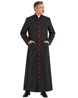 A man modeling a Classic Black Clergy Cassock with Red Trim with red trim and red front buttons, standing against a plain white background.