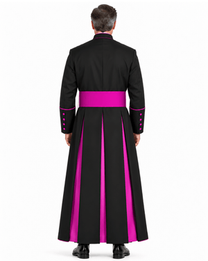 A man viewed from the back wearing a Classic Clergy Cassock With Magenta Trim at the waist and matching magenta piping details on the collar, cuffs, and sleeve buttons, against a plain white studio background.