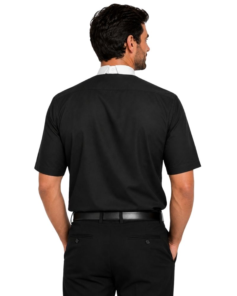 A man shown from the back wearing a black short-sleeve clerical shirt, black trousers, and a white collared shirt underneath, against a plain white background.