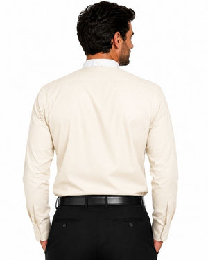 A man viewed from the back wearing a light cream-colored long-sleeve clerical shirt and black trousers, against a plain white background.
