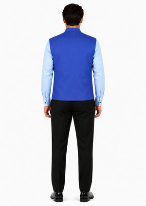 Man wearing a blue vest over a light blue shirt with black pants on a white background