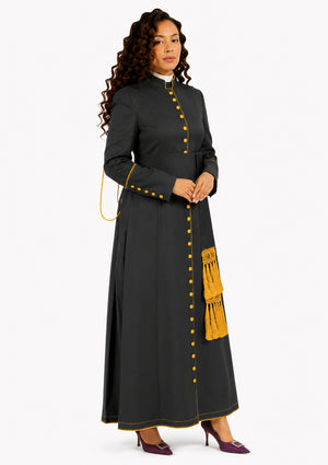 Woman wearing a black robe with yellow buttons and a fringed detail on a white background