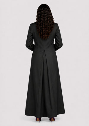 Person wearing a black cassock from behind on a white background