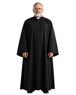 A man wearing a long black clerical robe with a high collar and front buttons, standing against a plain white background.
