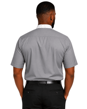 A man viewed from the back wearing a light gray short-sleeve clerical shirt, black trousers, and a black belt against a plain white background.
