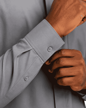 closeup of man wearing gray clerical shirt again a plain white background.