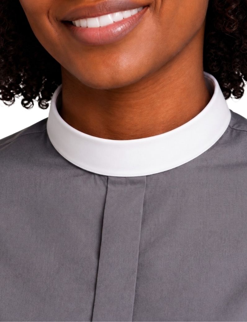 Close-up of a woman wearing a gray clerical shirt with a contrasting white high collar, cropped from the mouth to the chest.
