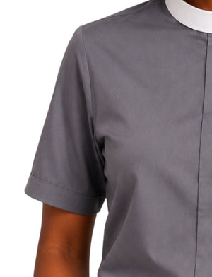 A close-up of a woman wearing a short-sleeve gray clerical shirt with a white collar, cropped from the chest up against a plain white background.