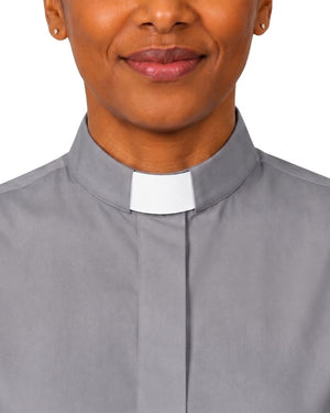 A close-up of a woman wearing a gray clerical shirt with a white clerical collar, shown against a plain white background.