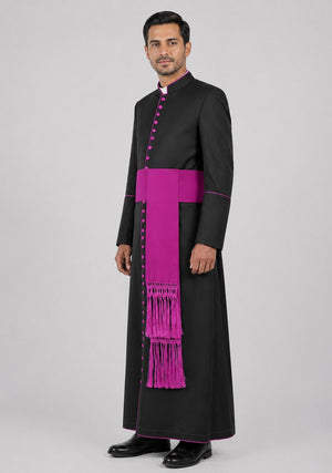 Man wearing a black robe with a purple stole on a gray background