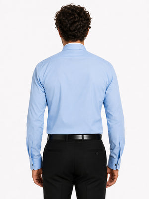 Man wearing a light blue clerical shirt and black pants on a white background