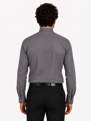Man wearing a gray clerical shirt and black pants on a white background