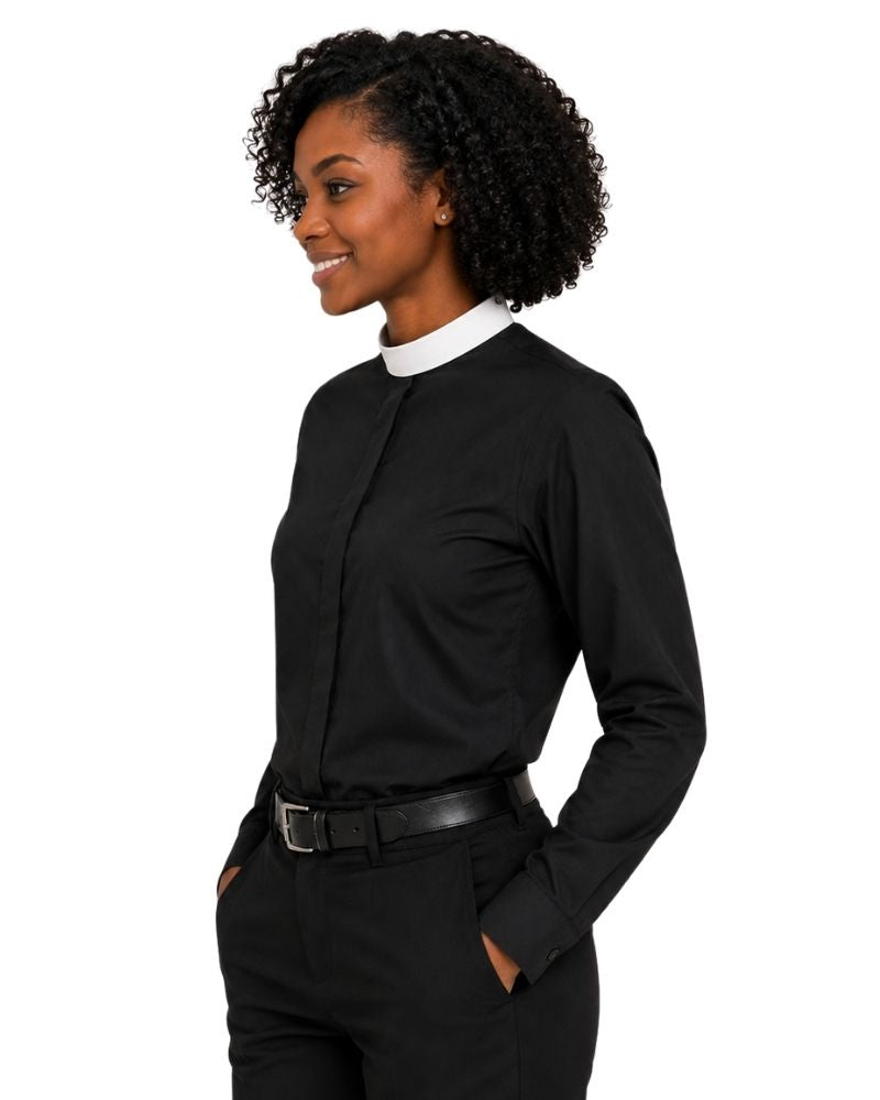 A woman shown from the left wearing a black long-sleeve clerical shirt with a white collar, paired with black trousers and a black belt, against a plain white background.