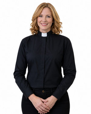 A smiling blonde woman wearing a black long-sleeve clerical shirt with a white collar, standing against a plain white background.