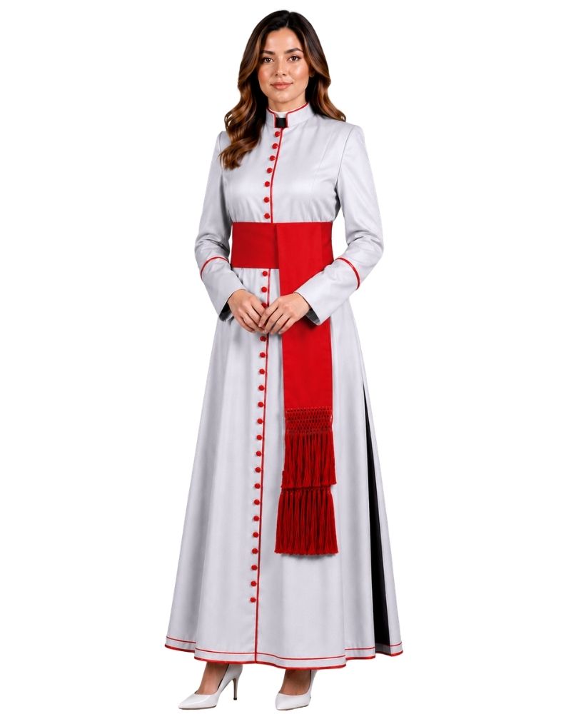 A woman modeling a long white cassock with a bold red waist sash, red decorative buttons down the front, red piping details, and a black side slit, set against a plain white background.