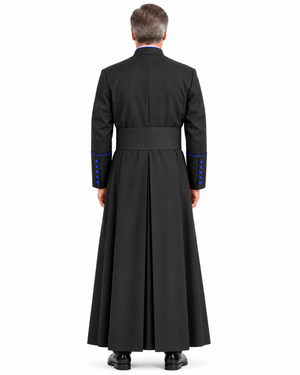 A man viewed from the back wearing Obsidian Royal Blue Clerical Cassock with a waist belt and blue button accents on the sleeves, against a plain white studio background.