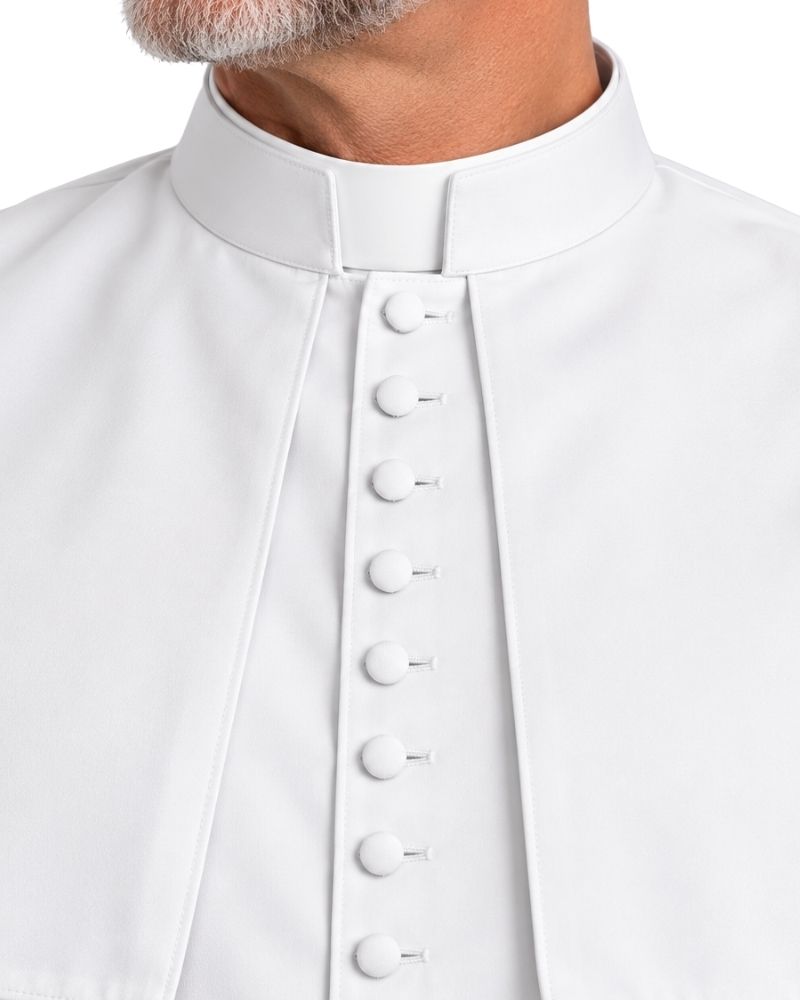 A close-up of a White Saint Cassock With Shoulder Cape with a central button placket, worn by a man whose neck and beard are partially visible against a plain white background.