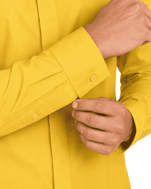 Close up of the man hands showing the sleeves of the yellow clerical shirt on the plain white background.
