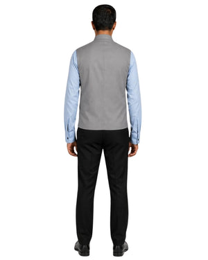 Man wearing a gray vest over a light blue shirt on a white background.