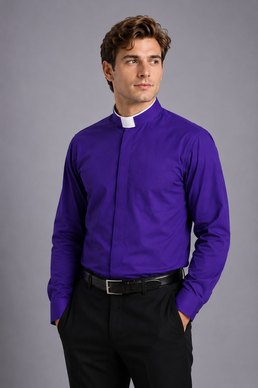 Man wearing a purple shirt with a clerical collar against a gray background