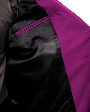 Man wearing a purple vest over a gray shirt on a white background