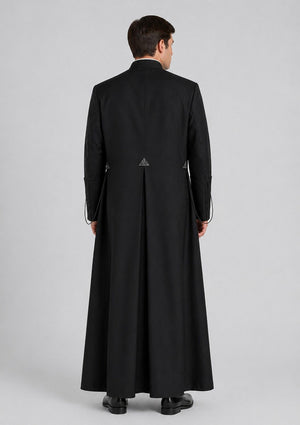 Man wearing a long black cassock on a gray background