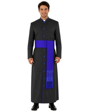 A man modeling a black clerical cassock with a bright royal blue sash and matching blue buttons, photographed against a plain white background.