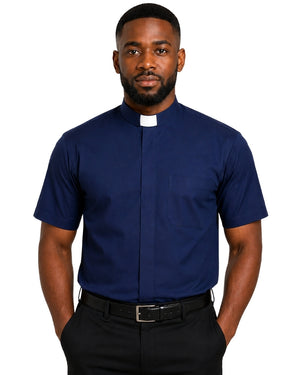 A man wearing a navy blue short-sleeve clerical shirt with a white collar tab, paired with black trousers and a black belt, against a plain white background.