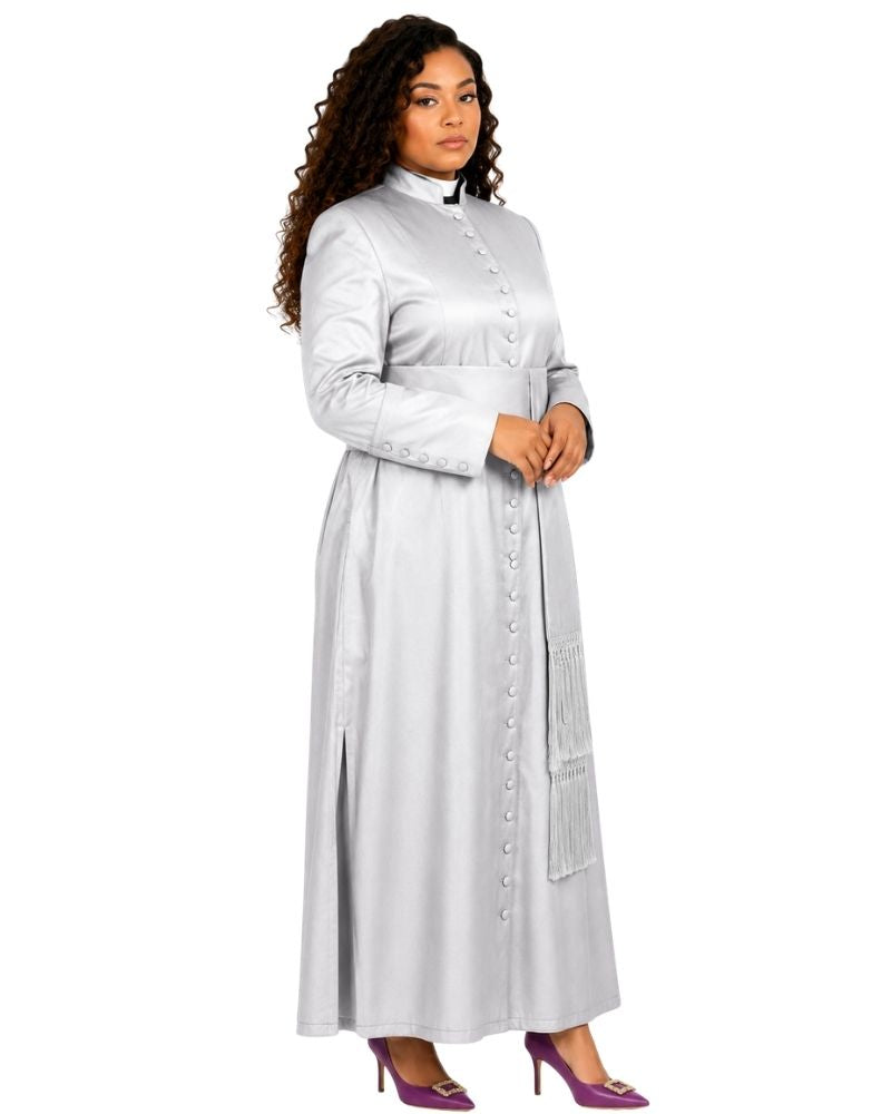 A woman modeling a long-sleeved, high-neck, button-front cassock in a light silver-gray color, paired with purple high heels, against a plain white background.