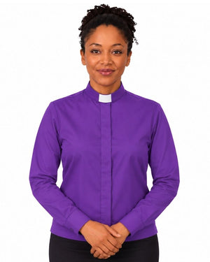 A woman wearing a purple long-sleeve clerical shirt with a white collar, standing against a plain white background.