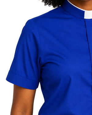 A close-up of a women wearing a royal blue short-sleeve collared shirt with a white collar trim, shown against a plain white background.