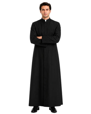 A man modeling a long black clerical robe with a white collar, standing with arms crossed against a plain white background.