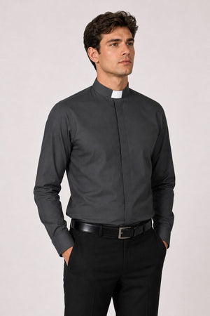 Man wearing a black clerical shirt with a white collar on a light gray background