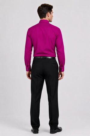 Man wearing a bright pink shirt and black pants on a white background