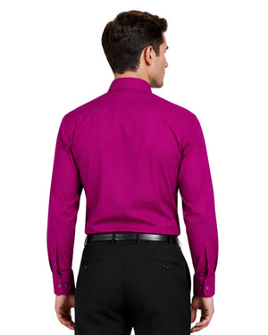 Man wearing a bright pink shirt and black pants on a white background