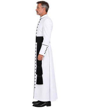 A man shown in profile wearing a White Clergy Cassock With Black Trim black buttons, and a black waist sash, photographed against a plain white studio background.