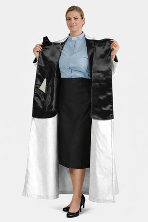 Woman holding a black and white dress with a plain background