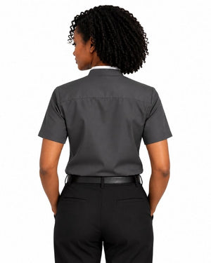 A woman shown from the back wearing a dark gray short-sleeve clerical shirt tucked into black trousers, against a plain white background.