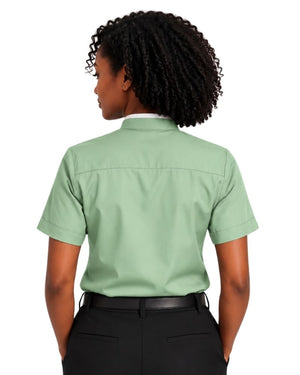 A woman shown from the back wearing a sage green short-sleeve clerical shirt tucked into black pants, against a plain white background.
