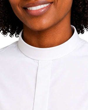 Close-up of a women wearing a white clerical shirt, showing the collar and upper chest against a light neutral background.