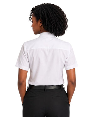 A woman with curly black hair is shown from the back wearing a white short-sleeve clerical shirt and black trousers against a plain white background.